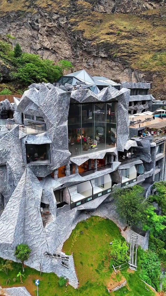 MoYe Snow Mountain Cliff Hotel built into a rugged mountainside