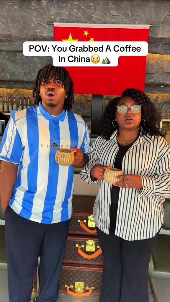 Two travellers holding coffee inside the hotel café