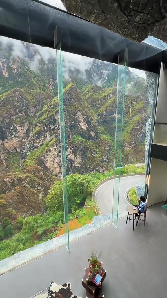 Floor-to-ceiling glass overlooking the misty Tiger Leaping Gorge landscape