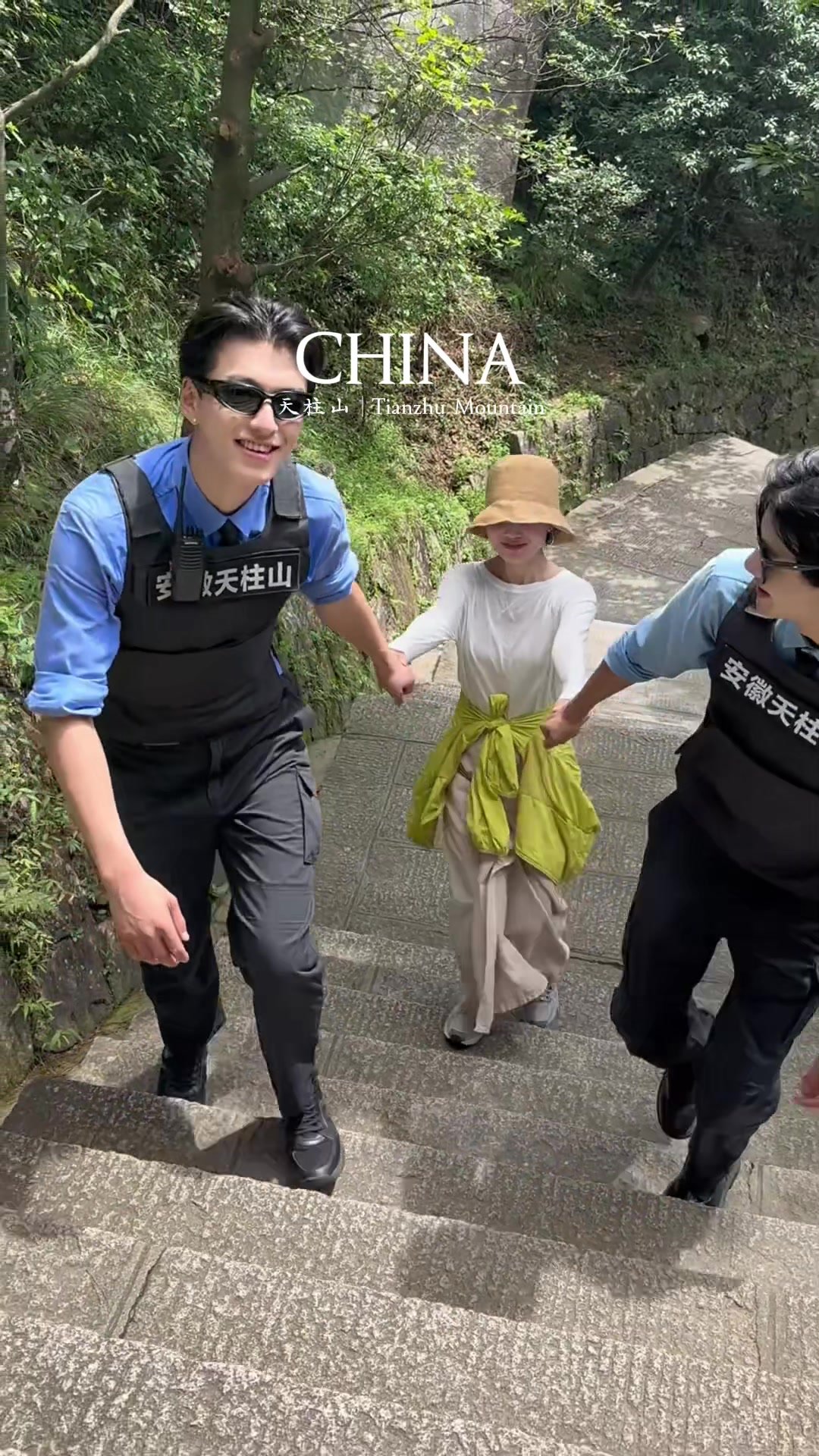 Security guards helping a visitor climb the steps at Tianzhu Mountain