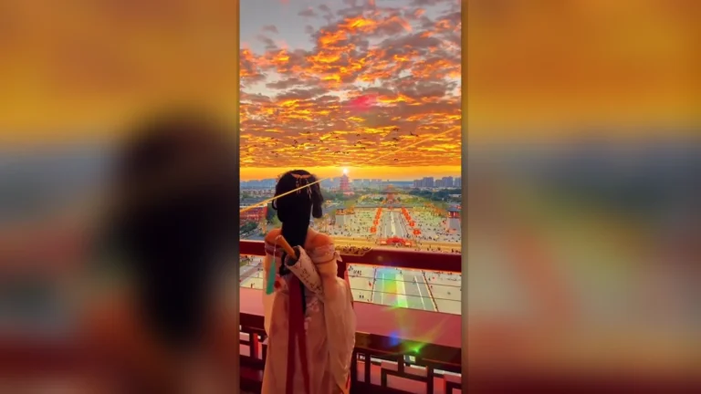 A traveler watches a fiery sunset from Xi’an City Wall in China